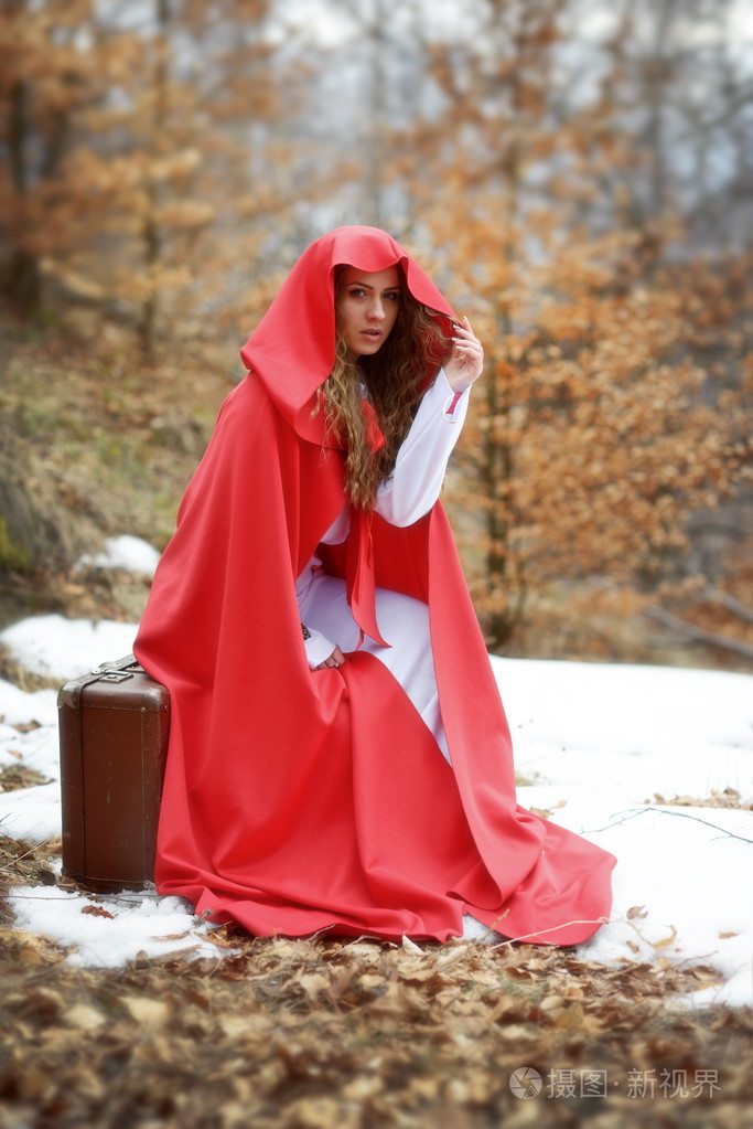 美丽的女人，红色的斗篷和手提箱