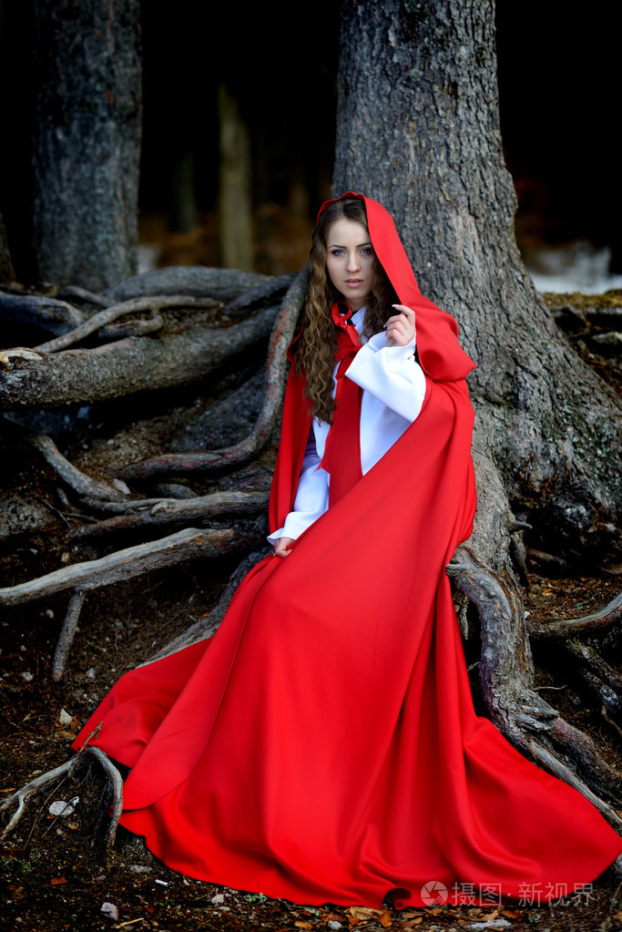 美丽的女人,与红色的斗篷,在树林里摆姿势