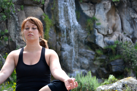 练习瑜伽有瀑布背景的女人