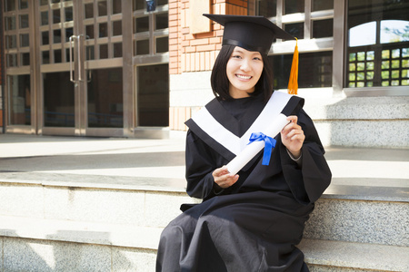 亚洲大学生在校园里举行一张文凭