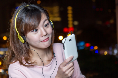 美丽年轻的亚洲女人，戴着黄色的耳机