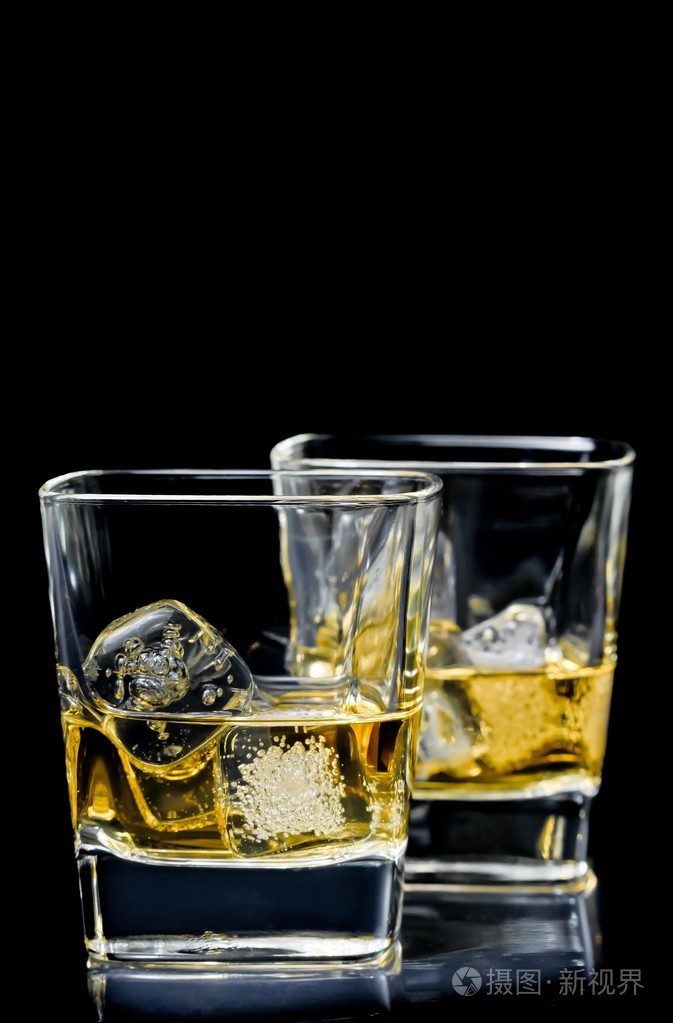 两杯酒精饮料的黑色背景上的冰