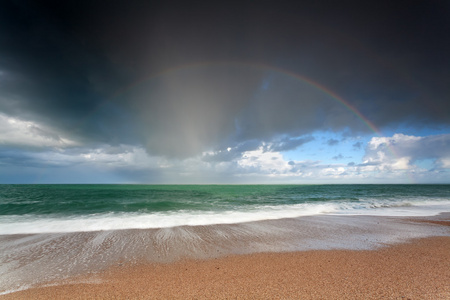 美丽的彩虹，在海洋波浪 ob 沙海滩