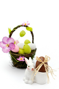 多彩漆的复活节彩蛋在篮子和蛋杯巧克力蛋
