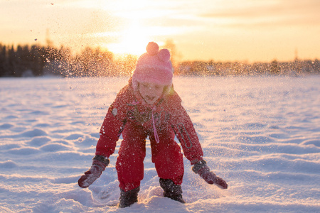 享受飘落的雪花在阳光下的孩子图片