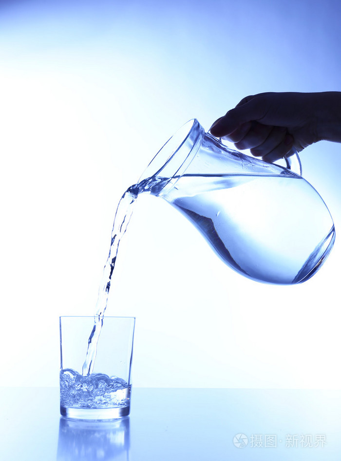 倒水入杯在蓝色背景