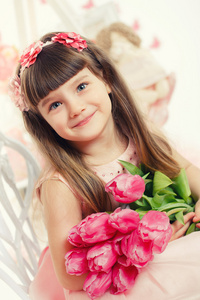 关小可爱的女孩，她手里拿着粉色的郁金香的肖像