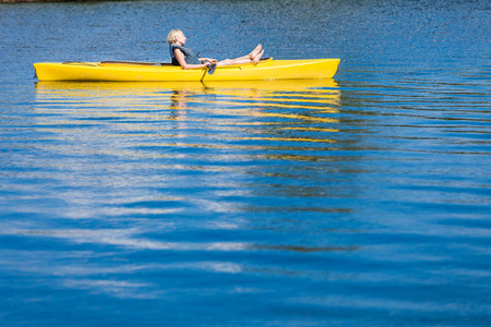平静的河流和女人放松一个皮艇图片