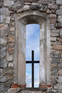 在窗口中的古代石教堂十字架