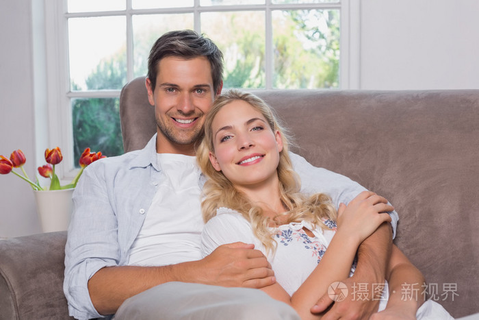 轻松幸福恩爱的夫妻坐在沙发上的肖像