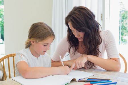 女人协助女儿的家庭作业