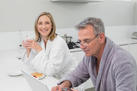 幸福的夫妇做在家网上购物的浴袍