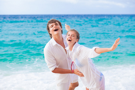 太阳镜中白色的衣服，在热带的海滩上享受他们的假期快乐年轻夫妇的肖像