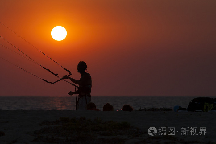 航行在日落时的 kitesurfer 的剪影