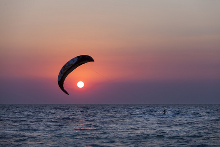 航行在日落时的 kitesurfer 的剪影