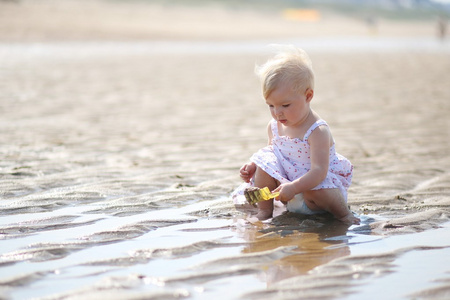 宝贝女孩玩水和沙子