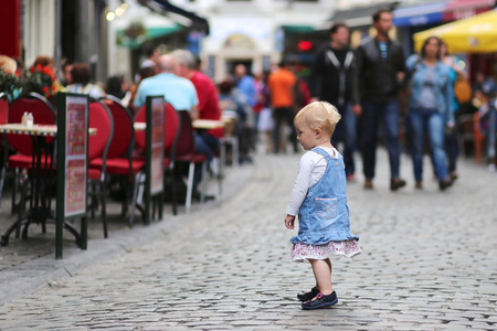 小女孩站在一个繁忙拥挤的街道