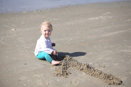 女孩坐在海岸的沙滩上