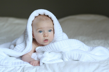 婴儿躺在大床上根据蜗杆柔软的白毛毯