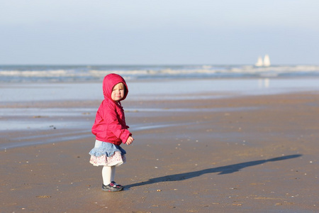 小女婴，她走在潮湿的沙滩