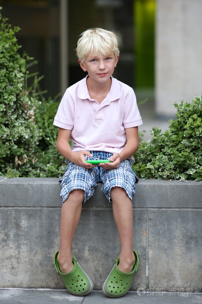 在触摸屏智能手机上玩小游戏的男孩