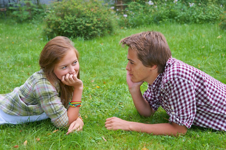 男孩和女孩 青少年躺在草地上