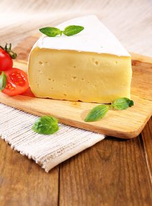 用番茄和罗勒，木制的桌子上的美味松软干乳酪。
