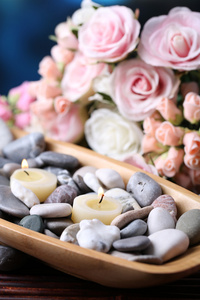 spa 石块与木碗，附近明亮的背景上的花朵蜡烛组成