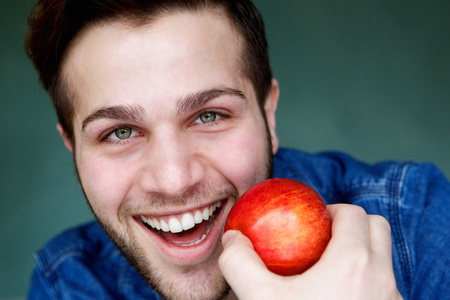 男人微笑着拿着红红的苹果
