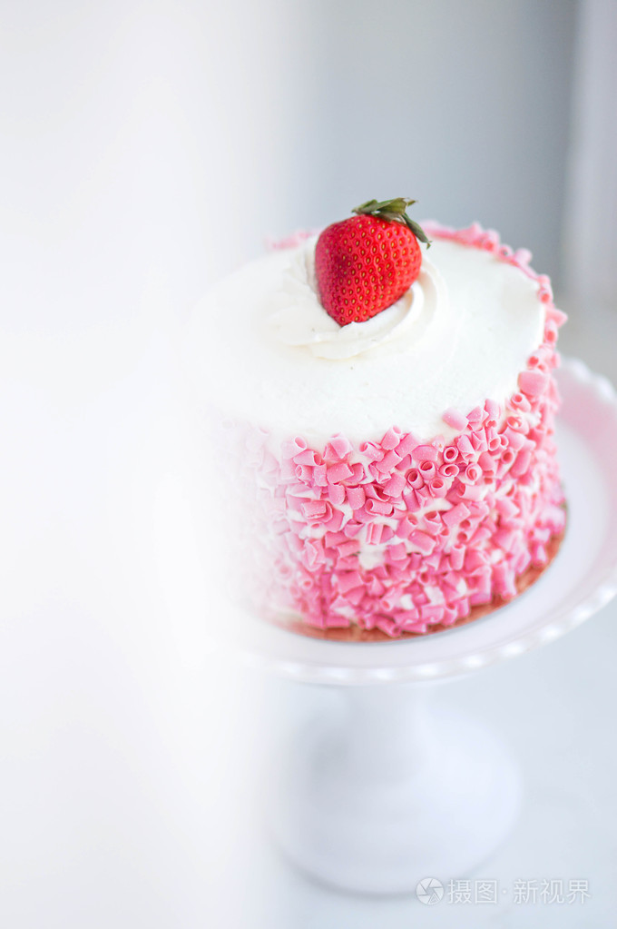 木制的背景上的白色奶油的草莓蛋糕