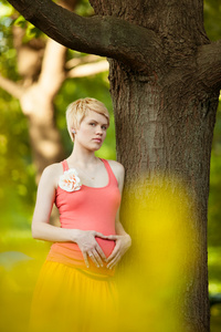 年轻的幸福的怀孕的女人的在自然中放松