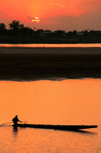 在日落时分，万象，老挝在湄公河上的剪影的船