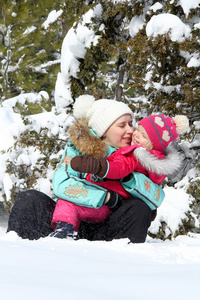 幸福的母亲和她蹒跚学步的女儿，在冬季公园玩