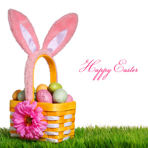 复活节彩蛋和兔子耳朵在绿色草地上的篮子图片