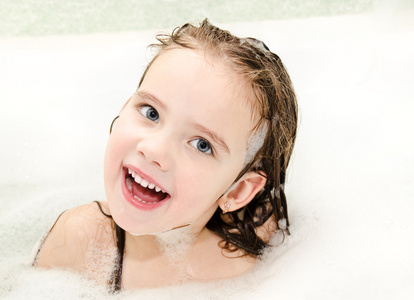 微笑的小女孩在用泡沫浴洗