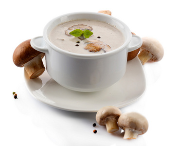 在白色的碗里，放盘子里，孤立的白色衬底上的蘑菇汤