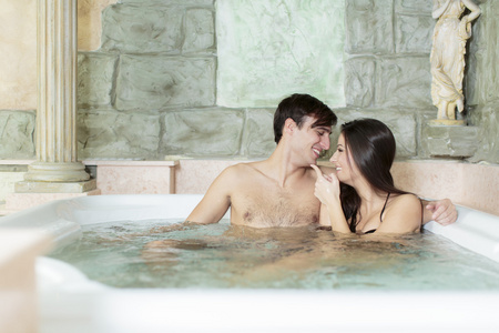 年轻的夫妇在热水浴缸中休息