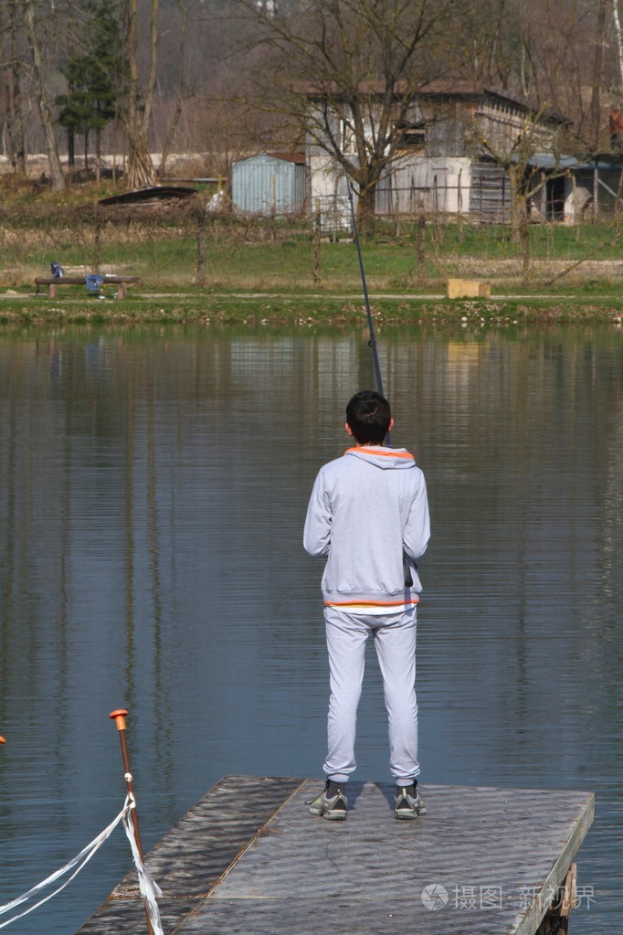 在湖边钓鱼附近的男孩照片-正版商用图片1f3oty-摄图新视界