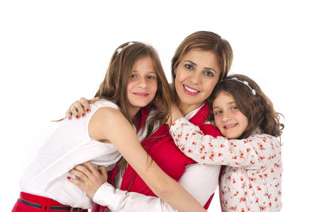 母亲和两个女儿在时髦的时尚服装中拥抱