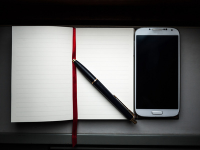一支钢笔在一边和一款智能手机与笔记本