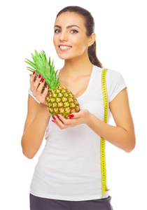 年轻健康的女性，与菠萝和测量磁带