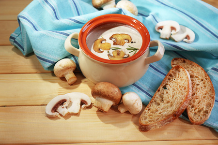 在锅中，餐巾，木制的背景上的蘑菇汤
