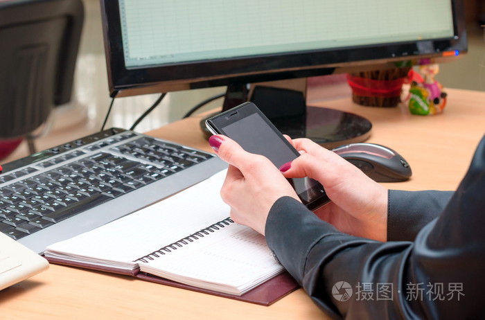女人用一部手机办公室工作