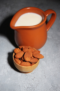 杏仁奶壶中用杏仁在碗里，颜色木制背景
