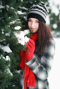 年轻漂亮的女人背后雪覆盖松