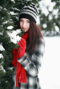 年轻漂亮的女人背后雪覆盖松