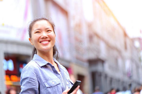 亚洲女人在购物街用手机