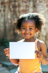 可爱的非洲女孩拿着白色的空白卡片。