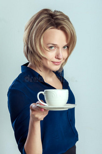微笑的女人拿着咖啡或茶杯