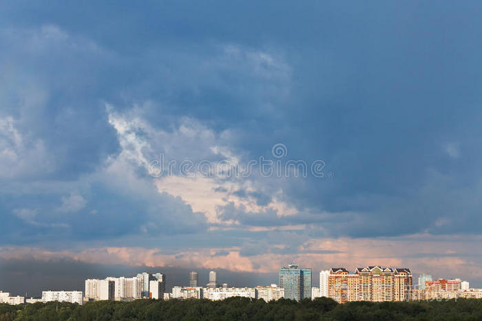 城市上空落日的深蓝色雨云